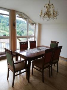 a dining room table with chairs and a chandelier at Ferienwohnung Rosemarie Wagner in Grafenau