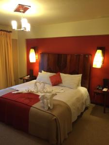1 dormitorio con 1 cama con 2 toallas en Royal Inn Hotel Puno, en Puno