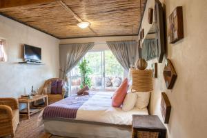a bedroom with a bed and a large window at Bedrock Guest Studios in Strand