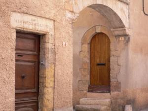 una entrada a un edificio con puerta de madera en B&B Charming room with view, en Montauroux