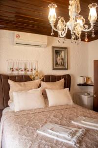 a bedroom with a large bed with a chandelier at Villa Teos Otel in Izmir