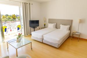 a bedroom with a white bed and a large window at Marina Club Lagos Resort in Lagos