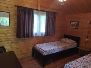a bedroom with two beds in a log cabin at Hanul Arcașului in Voila