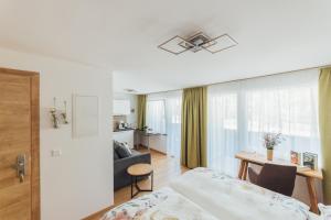 ein Schlafzimmer mit einem Bett und ein Wohnzimmer in der Unterkunft Naturoase Appartements Mirnock in Afritz