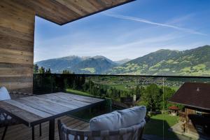 balcón con mesa de madera, sillas y montañas en Seven Reasons / Panorama View, en Hart im Zillertal