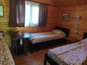 Cette chambre comprend deux lits, un bureau et une fenêtre. dans l'établissement Hanul Arcașului, à Voila