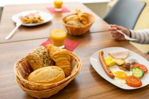 einen Tisch mit einem Frühstückskorb und Orangensaft in der Unterkunft Hotel Quellenhof in Baden-Baden