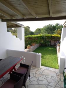 a patio with a table and chairs and a garden at To Pithari in Skiros