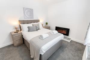 a bedroom with a large bed and a fireplace at The Valley Home - TV in every room! in Brynamman