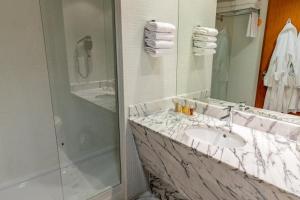 a bathroom with a marble sink and a shower at Marina Club Lagos Resort in Lagos