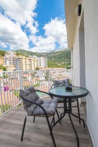 a table and chairs on a balcony with a view at Studio Apartment Urke in Budva +3 photos