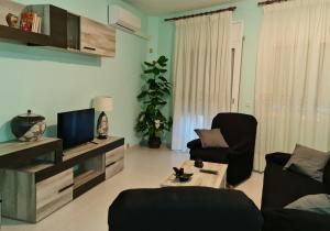 sala de estar con 2 sillas y TV en Casa Mirador, en Alcanar