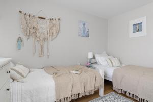 two beds in a bedroom with white walls at Baltiq Spot Rewa in Rewa