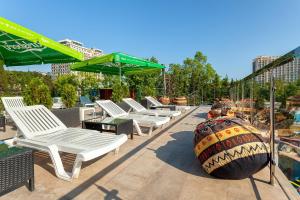 a row of lounge chairs and a large ball on a patio at Wellness СПА-Отель Грейс Арли in Adler
