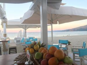 a table with a bowl of fruit on the beach at Makedos Sea View in Nea Vrasna