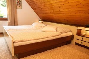 sypialnia z łóżkiem i drewnianym sufitem w obiekcie Počitniška hiša Pri Goričarju w mieście Bohinjska Bistrica