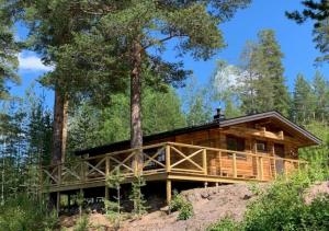 eine Blockhütte im Wald mit einem Baum in der Unterkunft Stuga Sälen Kläppen 7 bäddar uthyres veckovis Söndag till Söndag in Sälen