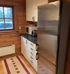 eine Küche mit einem Kühlschrank und einer Mikrowelle in der Unterkunft Stuga Sälen Kläppen 7 bäddar uthyres veckovis Söndag till Söndag in Sälen