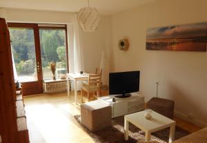 a living room with a television and a table at Ferienwohnung Habichtstal in Marburg an der Lahn