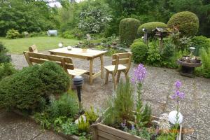 un giardino con tavolo, sedie e fiori di Ferienwohnung Habichtstal a Marburg an der Lahn