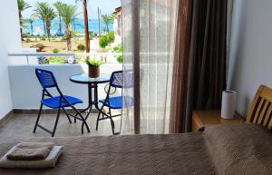 a bedroom with a bed and a balcony with a table and chairs at Mediterranean Seaside Authentic Beach House in Polis Chrysochous