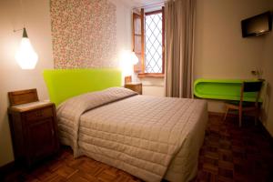 a bedroom with a bed with a green headboard at Hotel Diana in Lucca