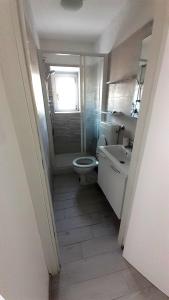 La salle de bains est pourvue de toilettes, d'un lavabo et d'une fenêtre. dans l'établissement MaRosa, à Montignoso