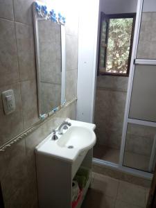 La salle de bains est pourvue d'un lavabo et d'un miroir. dans l'établissement Las Casuarinas, à Paraná