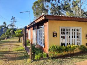 a small house with a white door on the side of it at Pousada Sítio Rústicu's in Domingos Martins