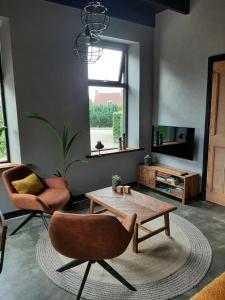 a living room with two chairs and a coffee table at De Sarrieshut in Houwerzijl