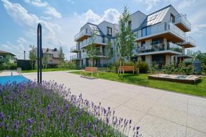 budynek z fioletowymi kwiatami przed nim w obiekcie Villa Nova Lux Apartment Wrocław Kowale by Noclegi Renters we Wrocławiu