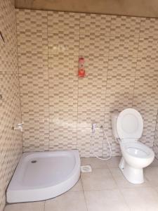 a bathroom with a toilet and a tub and a sink at The House of Black and White in Arusha