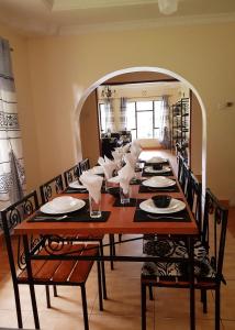 a dining room table with chairs and a large mirror at The House of Black and White in Arusha