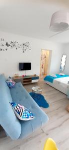 sala de estar con sofá azul y cama en Lennida Studio Apartman, en Kavran