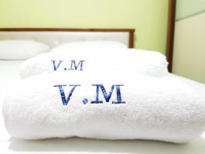 a stack of towels on a bed with the words vm vsvm at Villa Meminaj Vlore Sea view and Garden Vlore in Vlorë