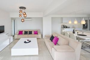 a living room with white furniture and pink pillows at Luxus Villa Skyla mit 5 Schlafzimmern & Meer-Blick in Kas