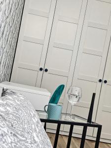 um quarto com uma cama e uma mesa com um copo de vinho em Polonia ART Apartments in the City Center em Katowice