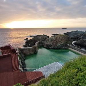 a large pool of water next to the ocean at Playa Ribeiría apartamento vacacional in Tapia de Casariego