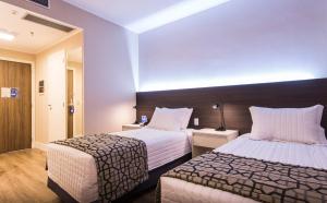 a hotel room with two beds with white sheets at Transamerica Executive Taboao Morumbi in Taboão da Serra +40 photos