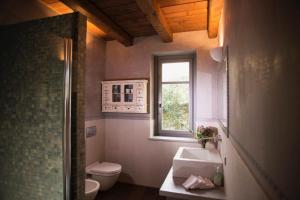 a bathroom with a sink and a toilet and a window at Cascina Canée in Angera