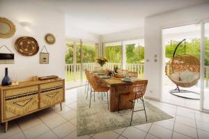 a dining room with a table and chairs at Villa Samasti - OVO Network in Lacanau