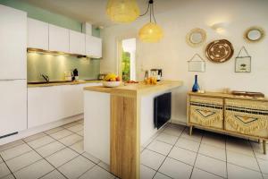 a kitchen with white cabinets and a counter top at Villa Samasti - OVO Network in Lacanau