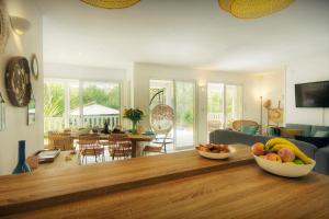 a living room with a table with a bowl of fruit on it at Villa Samasti - OVO Network in Lacanau