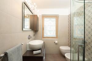 a bathroom with a toilet and a sink and a shower at Holiday House Livigno in Livigno