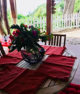 a table with a red table cloth and flowers on it at Les Terrasses Levantines in Île du Levant