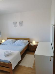 Schlafzimmer mit einem Bett und einem weißen Tisch in der Unterkunft Apartment Milka Vir in Vir