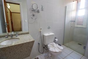 a bathroom with a shower and a toilet and a sink at Hotel Nacional Inn Araxá Previdência in Araxá