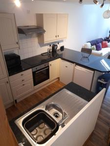 a kitchen with a sink in the middle of it at Town centre cottage in Tewkesbury
