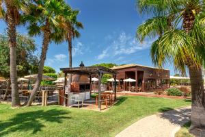 un complejo con palmeras y un restaurante en AP Adriana Beach Resort, en Albufeira