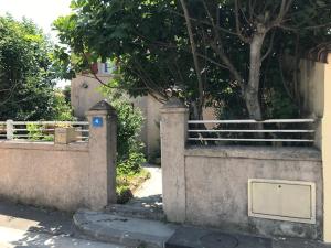 a concrete fence with a tree in the background at Chambre climatisée avec sdb privée dans une villa avec piscine ouverte d'avril à mi octobre in Marseille